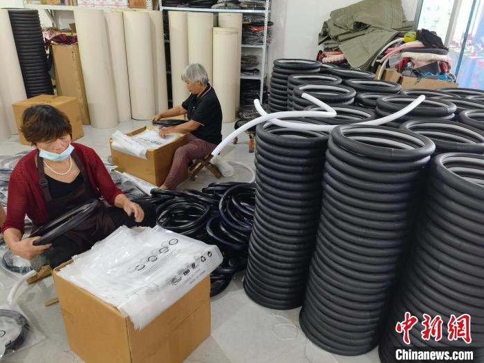 圖為村民在汽車飾品企業(yè)生產(chǎn)車間中工作?！巫雍?攝