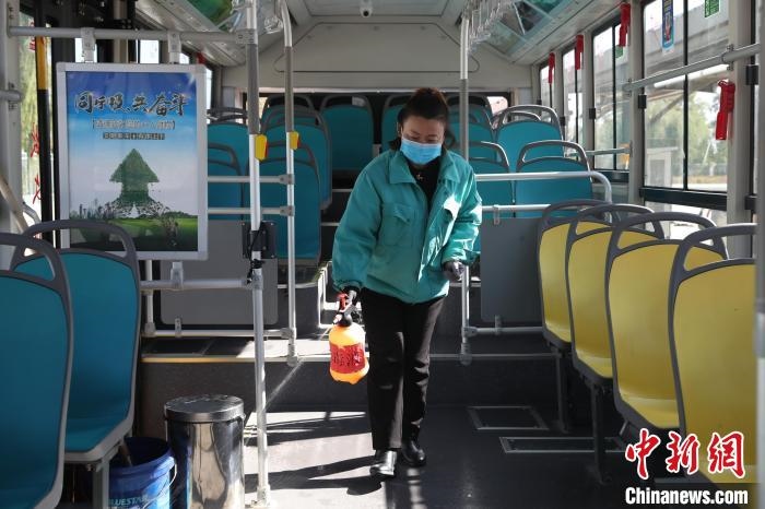 工作人員正在對(duì)公交車進(jìn)行消殺?！∮诰?攝
