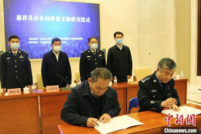 山東博物館館長(zhǎng)鄭同修和嘉祥縣人民政府副縣長(zhǎng)、公安局局長(zhǎng)趙健簽署移交協(xié)議?！≮w曉 攝