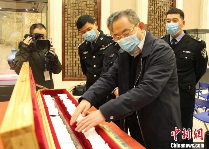 山東博物館館長(zhǎng)鄭同修介紹涉案文物龍首錯(cuò)銀木柲銅杖。　趙曉 攝