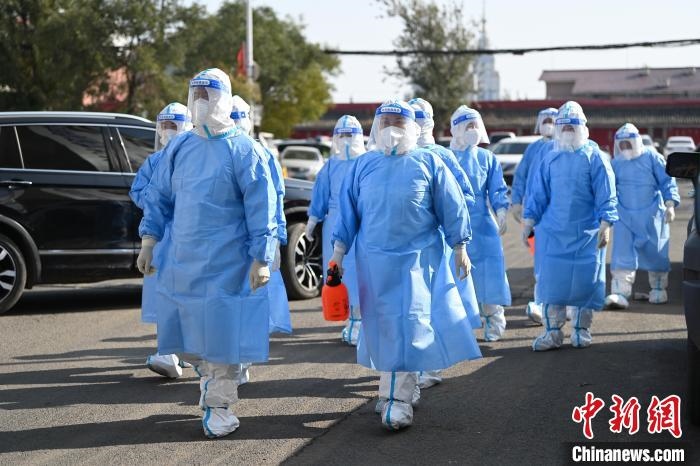 圖為醫(yī)務(wù)人員在封閉小區(qū)做防控工作?！⑽娜A 攝