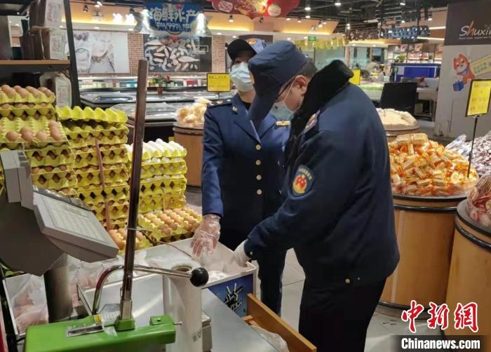 圖為疫情期間，甘肅嘉峪關(guān)市場(chǎng)監(jiān)管局工作人員檢查蔬菜市場(chǎng)?！?柴佳楠 　攝