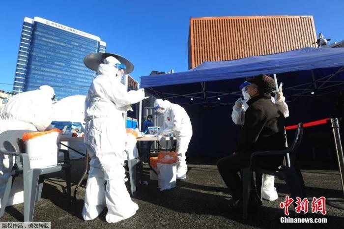 資料圖：韓國首爾，醫(yī)務(wù)人員對市民進行新冠病毒檢測。