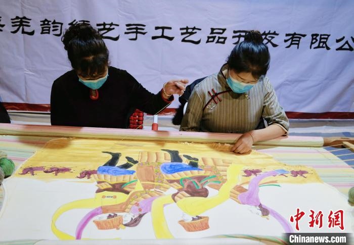 圖為皮繡藝人在市集上“秀”指尖技藝。　馬銘言 攝