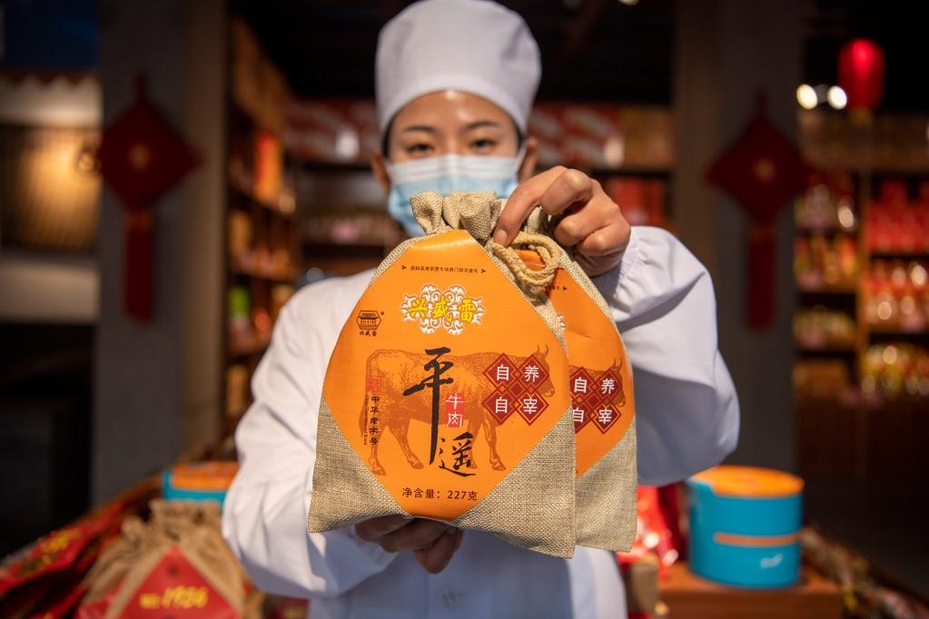 1月27日，在平遙古城南大街的一家平遙牛肉店內(nèi)，工作人員展示一款牛肉產(chǎn)品。新華社記者 楊晨光 攝