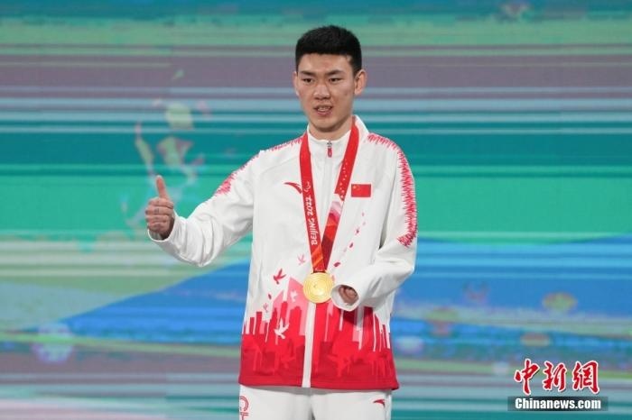 3月6日，梁景怡在延慶頒獎廣場領(lǐng)獎臺上豎起大拇指。當日，在國家高山滑雪中心舉行的北京2022年冬殘奧會殘奧高山滑雪男子超級大回轉(zhuǎn)—站姿決賽中，中國選手梁景怡奪得冠軍。 <a target='_blank' href='/'>中新社</a>記者 楊華峰 攝