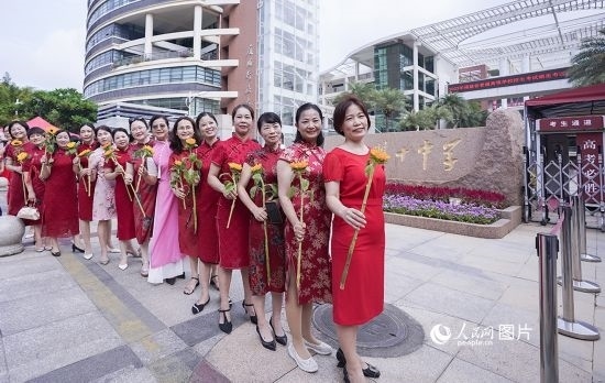 6月7日一早，廈門雙十中學(xué)考生家長(zhǎng)們身穿旗袍，手拿向日葵在考場(chǎng)外為孩子加油打氣，寓意“旗開得勝，一舉奪魁”。人民網(wǎng)記者 陳博攝