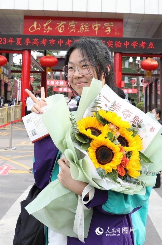 6月7日高考首日，山東67萬考生走進(jìn)考場(chǎng)，拼搏逐夢(mèng)。在山東省實(shí)驗(yàn)中學(xué)考點(diǎn)，考生進(jìn)考場(chǎng)前手捧向日葵花拍照留念，寓意“一舉奪魁”。人民網(wǎng)記者 劉祺攝