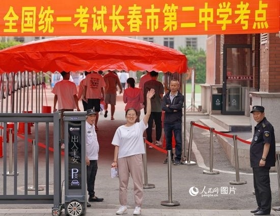 6月7日，在長(zhǎng)春市第二中學(xué)考點(diǎn)，一名考生信心滿滿進(jìn)入考場(chǎng)，并與家長(zhǎng)揮手致意。人民網(wǎng)記者 李洋攝
