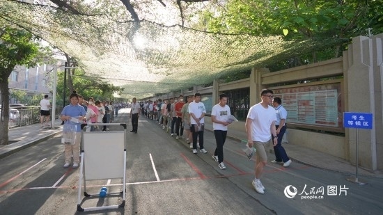 6月7日，烏魯木齊市第七十中學(xué)門口，考生們有序進(jìn)入考場(chǎng)。人民網(wǎng) 李欣洋攝