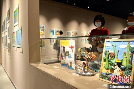 圖為家長帶著孩子參觀展覽。呂明 攝