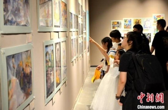 圖為家長帶著孩子參觀展覽。呂明 攝