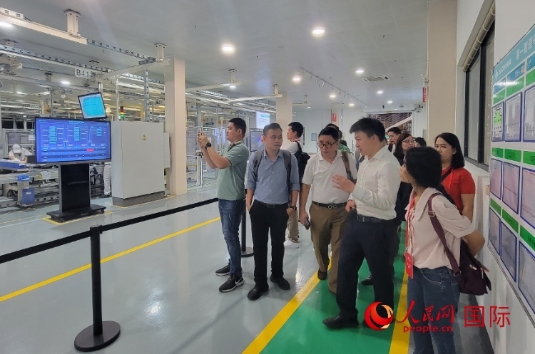 廣汽埃安工作人員向外媒記者進(jìn)行介紹。人民網(wǎng) 寧玉瑛攝