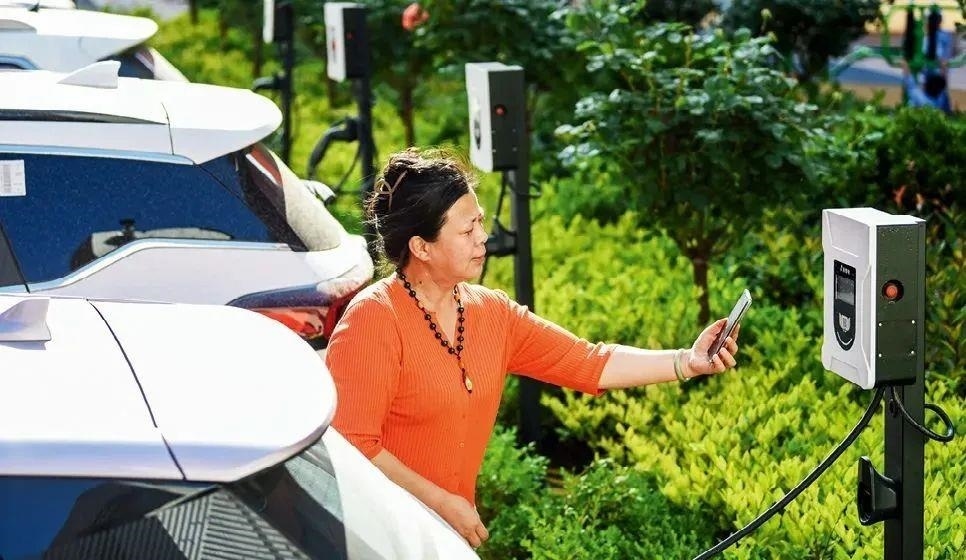 2023年5月24日，山東省膠州市新立街小區(qū)內(nèi)一位居民使用電動汽車充電樁掃碼充電。該小區(qū)加裝各類智慧設(shè)備，打造“智慧社區(qū)”，為居民生活帶來便利。