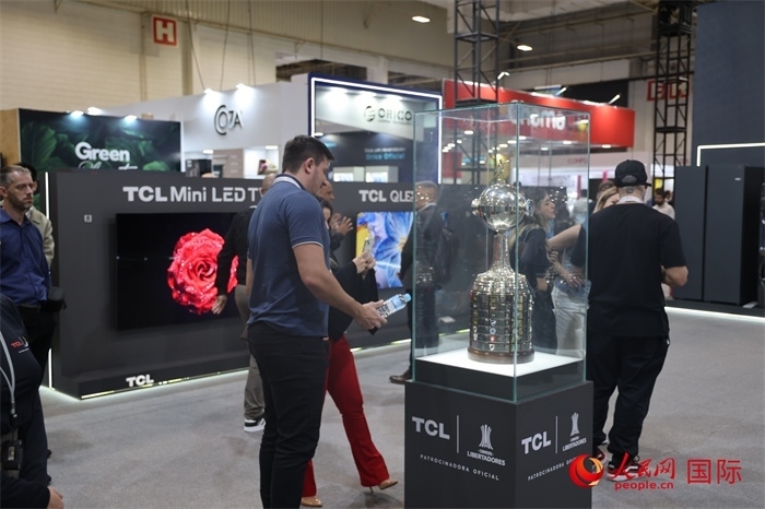 參觀者在TCL展臺前觀看南美解放者杯獎杯，據(jù)介紹，TCL是南美解放者杯（2023—2026賽季）全球官方合作伙伴。（人民網(wǎng)記者 時元皓攝）