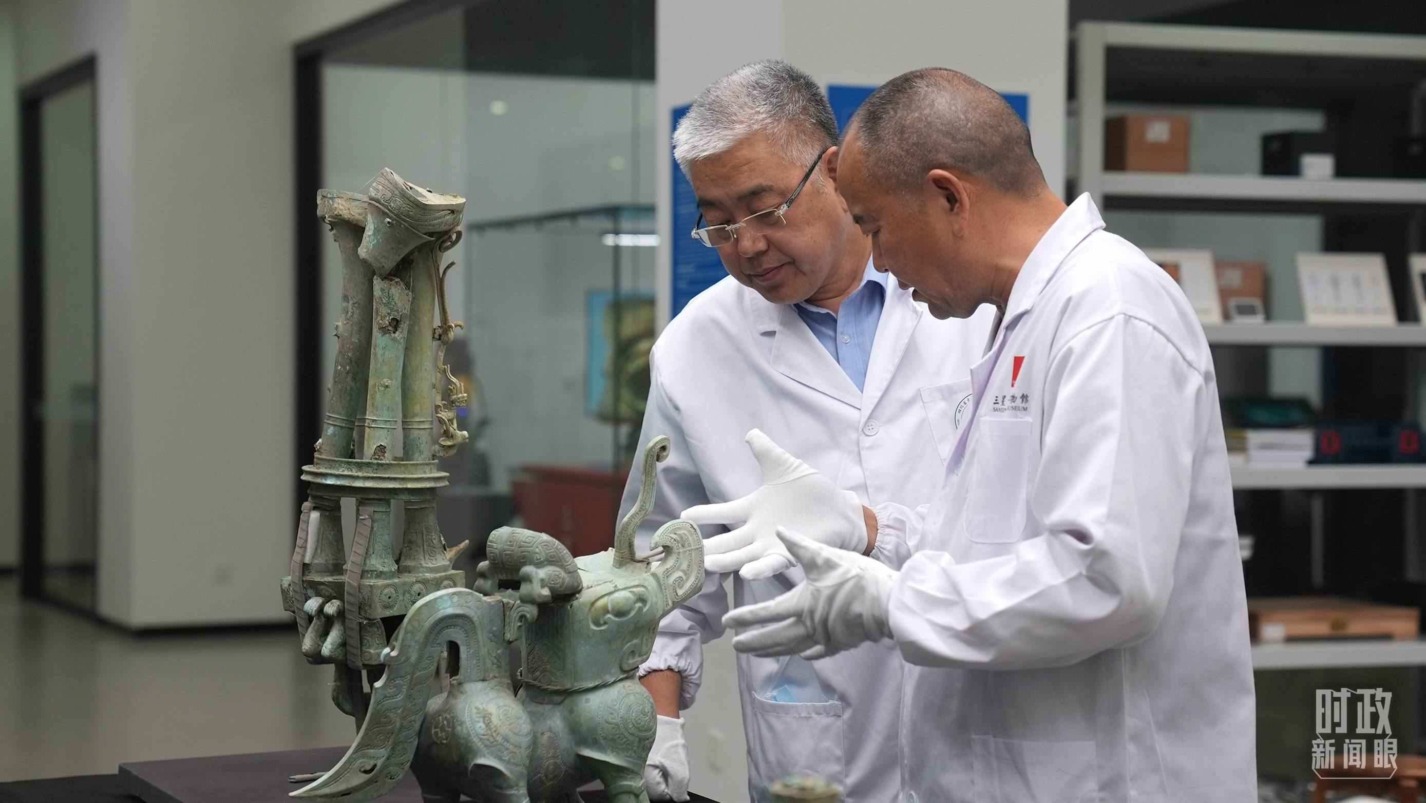 △三星堆文保專家正在就修復(fù)方案進行討論。（總臺央視記者劉琦拍攝）