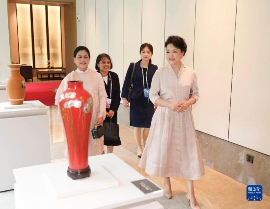 7月27日下午，國家主席習近平夫人彭麗媛在四川成都會見陪同印度尼西亞總統(tǒng)佐科來華出席第31屆世界大學生夏季運動會開幕式并訪華的總統(tǒng)夫人伊莉亞娜。這是彭麗媛和伊莉亞娜欣賞成都特色非遺工藝品。新華社記者 丁林 攝