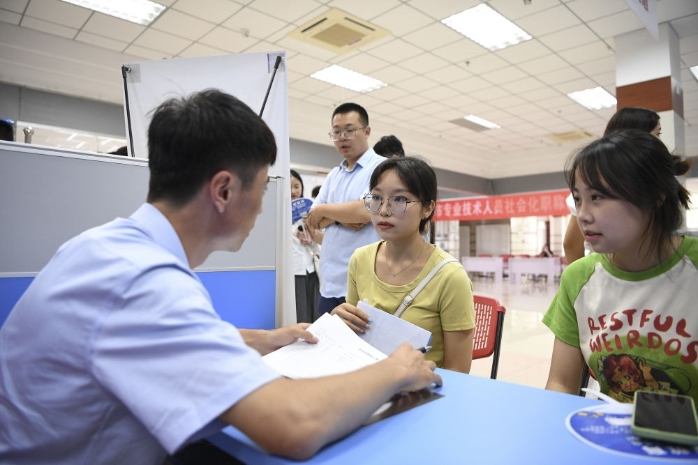 2023年7月29日，“揚(yáng)就業(yè)之帆，啟夢(mèng)想之旅”2023年寧夏（銀川）離校未就業(yè)高校畢業(yè)生招聘會(huì)在寧夏（銀川）人力資源服務(wù)產(chǎn)業(yè)園舉行。求職者（右）在招聘會(huì)現(xiàn)場(chǎng)與用人單位交流。新華社記者 馮開華 攝