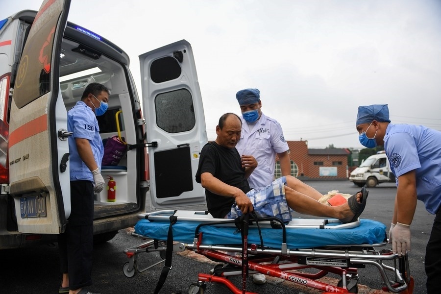 8月1日，在北京市門(mén)頭溝區(qū)妙峰山鎮(zhèn)妙峰山民族學(xué)校臨時(shí)安置點(diǎn)，北京急救中心工作人員在轉(zhuǎn)運(yùn)一名受傷村民。新華社記者 鞠煥宗 攝