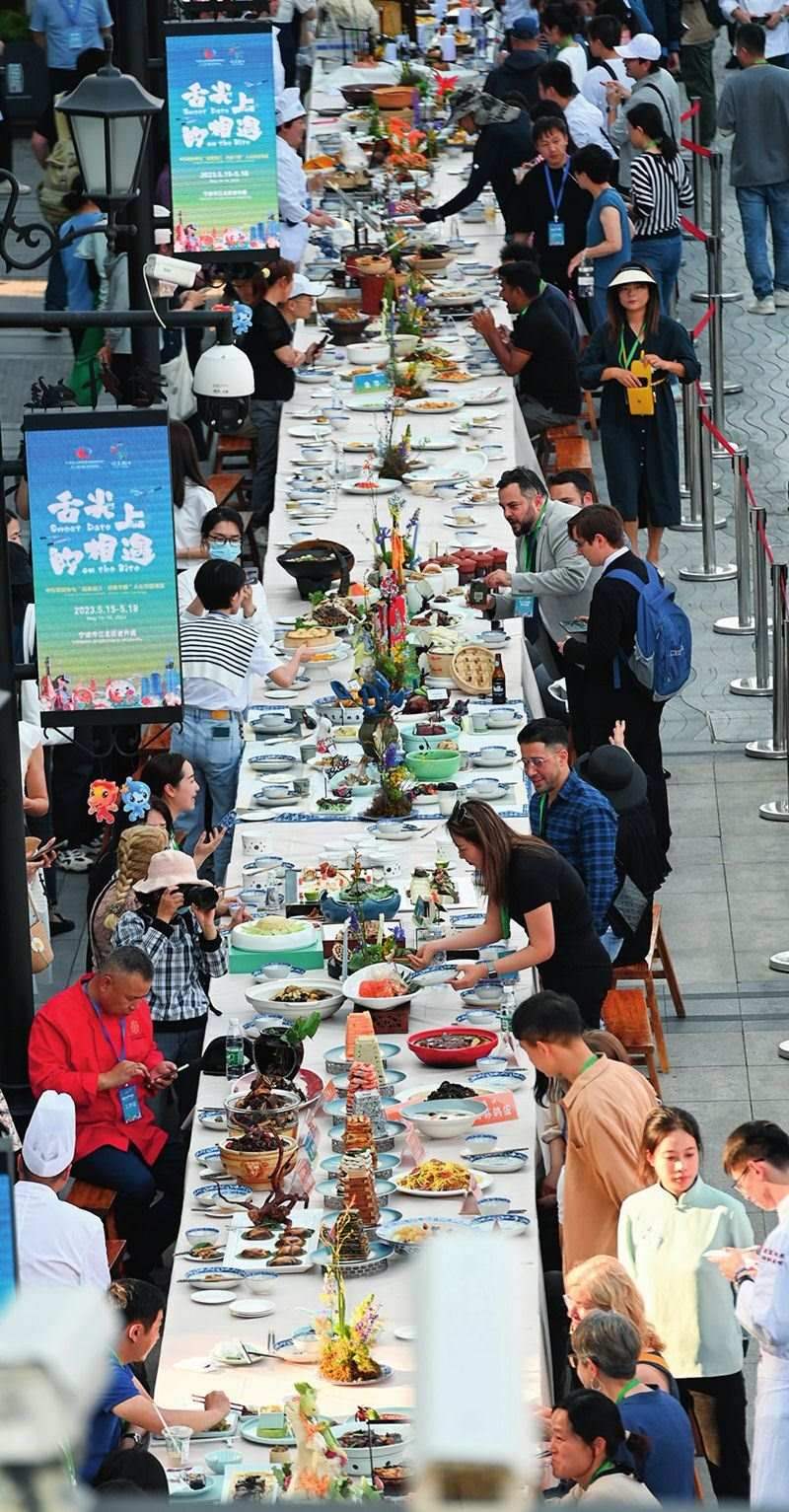 市民和游客在寧波舉辦的第三屆中國—中東歐國家博覽會(huì)暨國際消費(fèi)品博覽會(huì)上品嘗融合中國和中東歐美食的長桌宴（2023年5月15日攝）。黃宗治攝/本刊