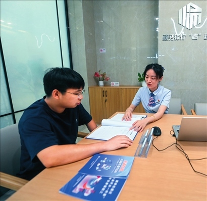 在杭州市臨安區(qū)政務(wù)服務(wù)中心的“為企服務(wù)中心”，黨員志愿者（右）解答企業(yè)主的疑問（2023年7月7日攝）。徐昱攝/本刊