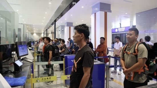 6月13日，乘坐中老鐵路國際旅客列車的旅客在磨憨邊檢大廳排隊(duì)候檢。李揚(yáng) 攝