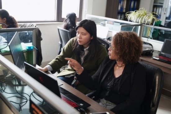 梅德哈妮（右）與中國同事討論設(shè)計方案。受訪對象供圖