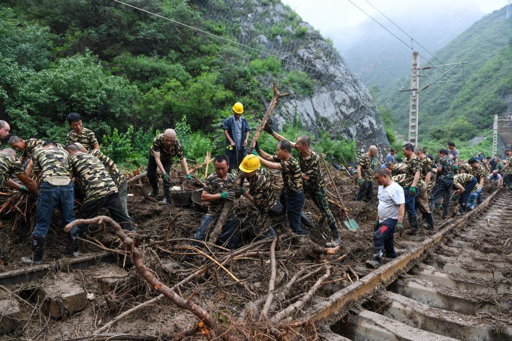 8月1日，在北京市門頭溝區(qū)水峪嘴村附近一段被阻斷的鐵路線上，中鐵六局工作人員在清理軌道上的雜物，全力恢復(fù)交通。新華社記者 鞠煥宗 攝