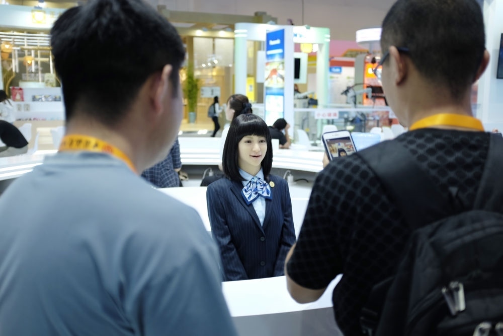 9月1日，媒體記者在國家會議中心與服務機器人互動。新華社記者 劉夢琪 攝