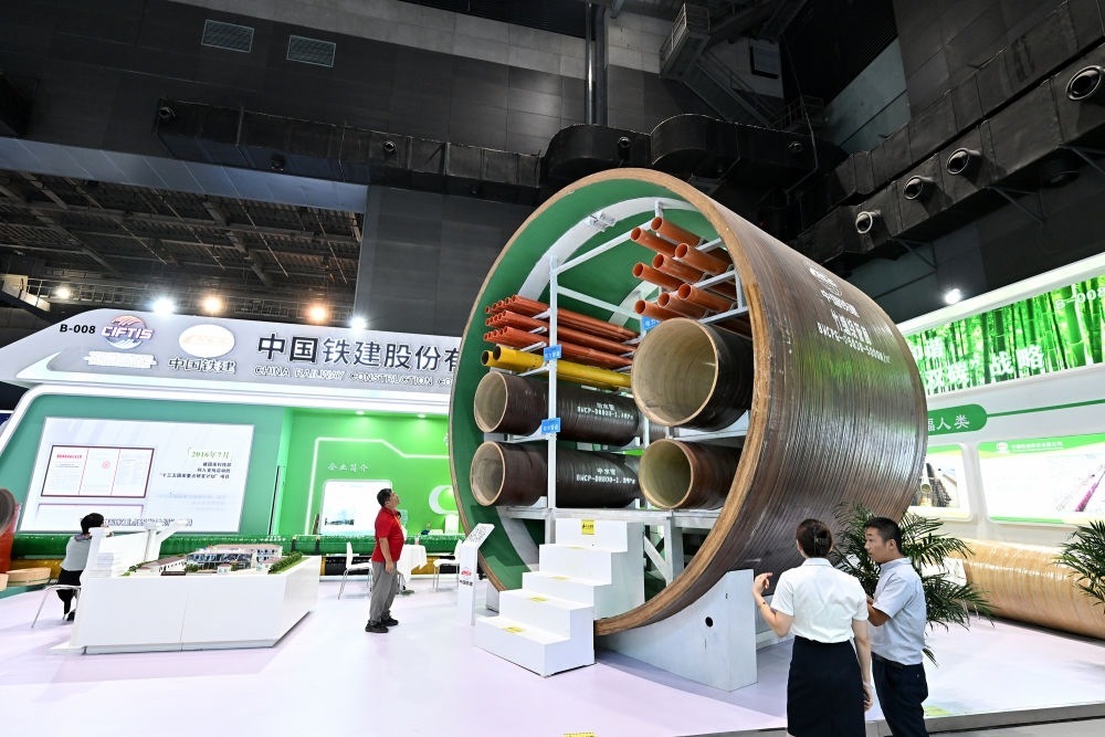 9月2日，在國(guó)家體育館舉行的服貿(mào)會(huì)環(huán)境服務(wù)專題展上，客商在中國(guó)鐵建展位竹纏繞管廊旁了解信息。新華社記者 李鑫 攝
