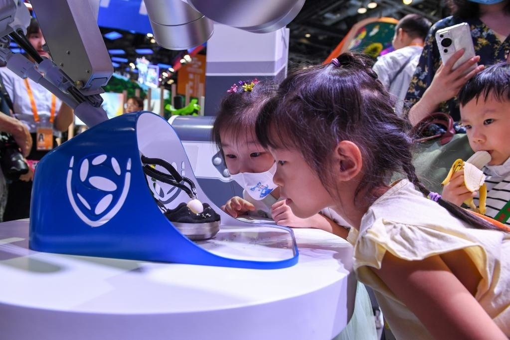 9月3日，幾名小朋友在國家會議中心觀看單孔腔鏡手術(shù)機器人展示。新華社記者 鞠煥宗 攝