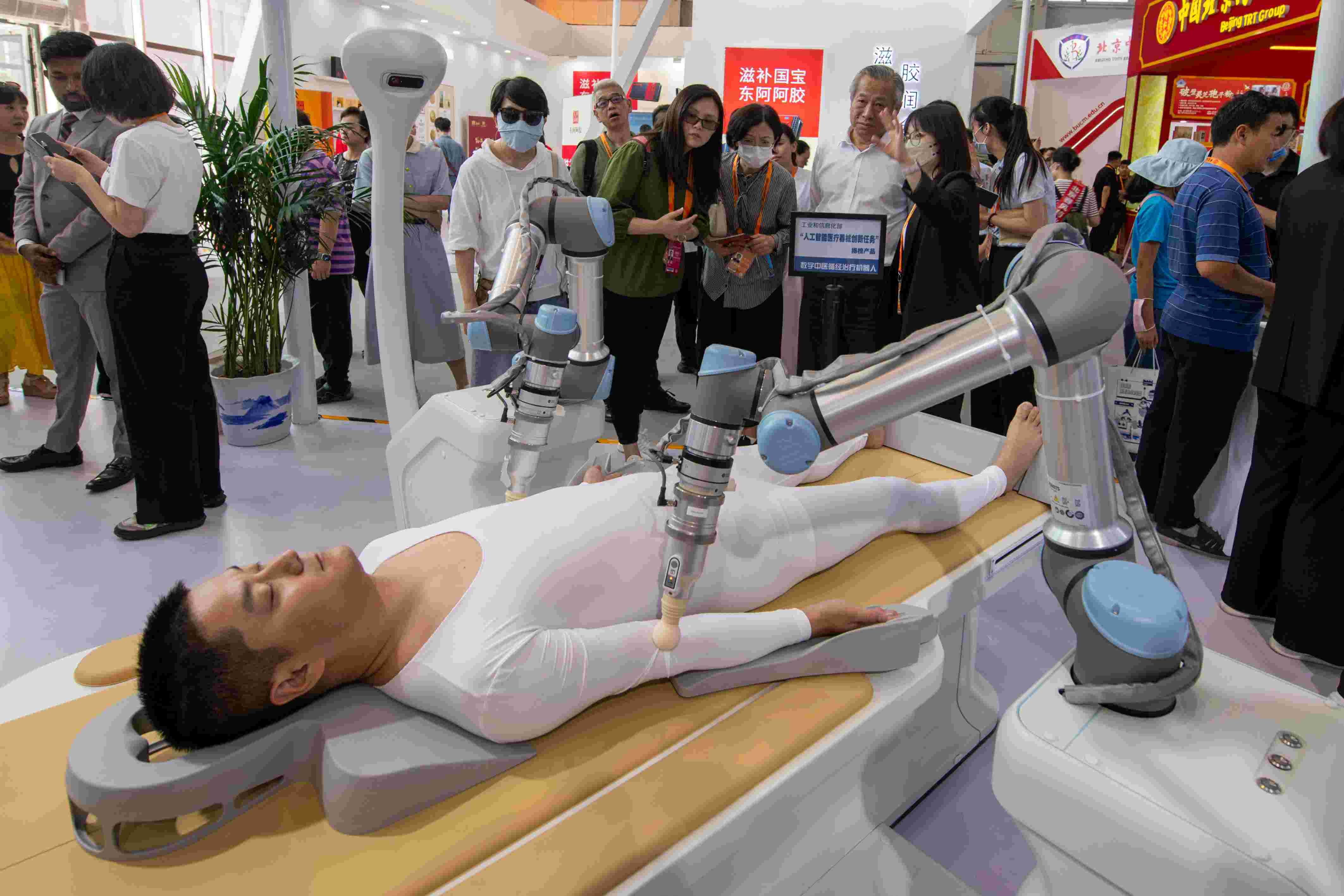 在位于首鋼園的健康衛(wèi)生服務(wù)展區(qū)，觀眾正在參觀數(shù)字中醫(yī)循經(jīng)治療機(jī)器人。人民網(wǎng)記者 翁奇羽攝