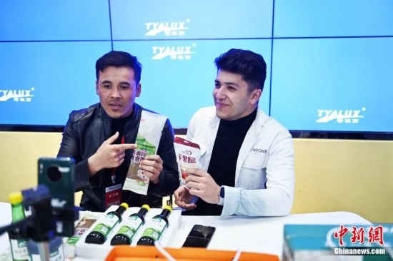 2023年3月，甘肅省慶陽(yáng)市環(huán)縣電商創(chuàng)業(yè)孵化基地內(nèi)，來(lái)自蘭州文理學(xué)院的塔吉克斯坦留學(xué)生正在協(xié)助主播直播帶貨當(dāng)?shù)剞r(nóng)特產(chǎn)品。李亞龍 攝