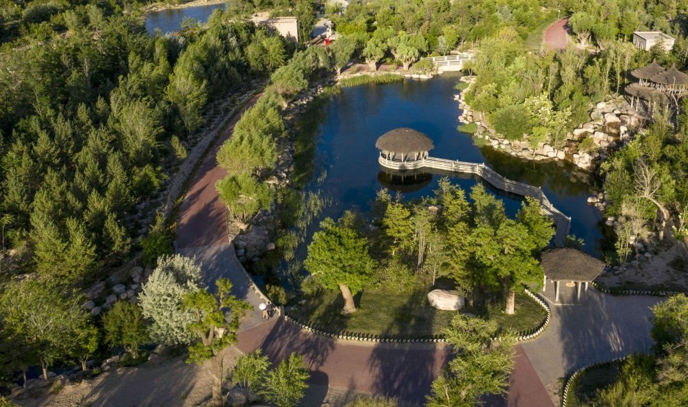 坐落在寧夏銀川市賀蘭山腳下的賀蘭山運動休閑公園（2021年5月27日攝，無人機照片）。這里曾是一片砂石采礦塌陷區(qū)，當?shù)赝ㄟ^植被景觀再造、水系建設(shè)、現(xiàn)代管網(wǎng)鋪建等手段，重新利用廢石、廢坑及各類廢棄建筑材料，把這里變成一座免費開放的主題公園。新華社記者 馮開華 攝