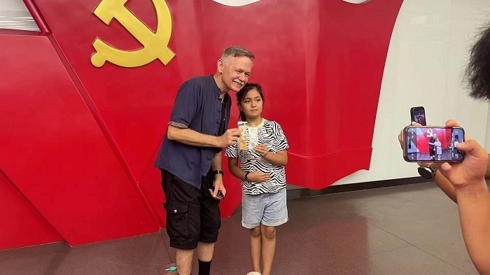 潘維廉和志愿講解員紀念合影。主辦方供圖