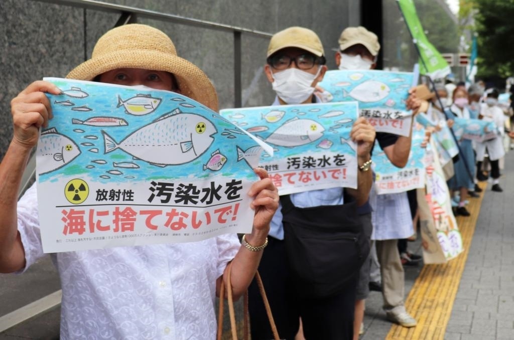 8月24日，日本民眾手持“不要將污染水扔進大?！钡葮苏Z在東京電力公司總部前集會，抗議日本政府和東電公司無視民意啟動核污染水排海。新華社記者楊光攝