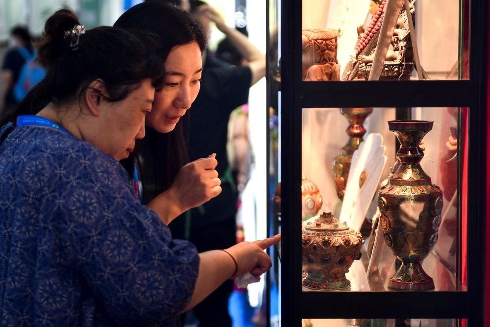 △2023年8月24日，參觀者在第十四屆中國—東北亞博覽會現(xiàn)場選購尼泊爾特色商品。