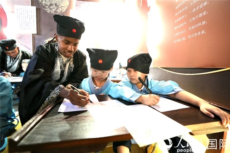 圖為選手與同學(xué)們一起寫書法。人民網(wǎng) 盧鵬宇攝