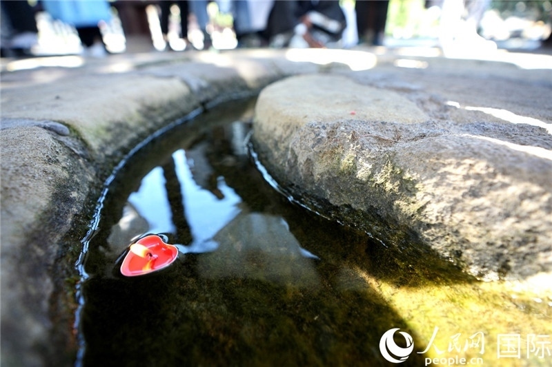 圖為水渠里流過的“桃心”蠟燭。人民網(wǎng) 盧鵬宇攝