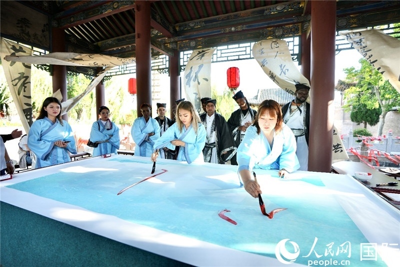 選手們提筆書寫“家園”二字。人民網(wǎng) 盧鵬宇攝