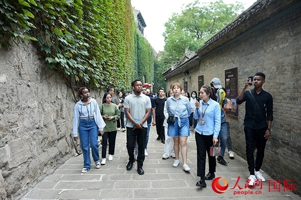 選手們認真聆聽導(dǎo)游講解。人民網(wǎng) 盧鵬宇攝