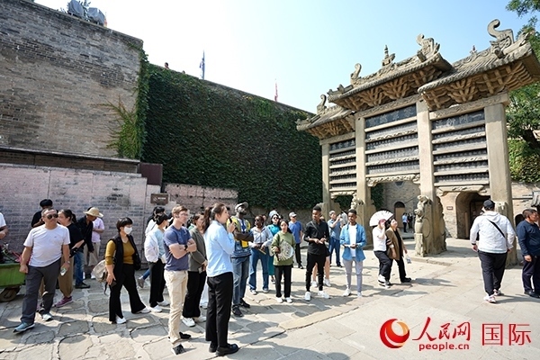 選手們認真聆聽導(dǎo)游講解。人民網(wǎng) 盧鵬宇攝