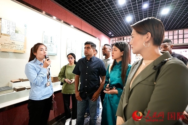 選手們認真聆聽導(dǎo)游講解。人民網(wǎng) 盧鵬宇攝