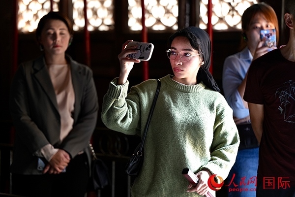 選手顏青（蘇丹）用手機記錄所見所感。人民網(wǎng) 盧鵬宇攝