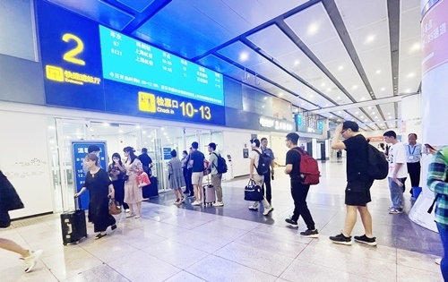 在快速進(jìn)站廳前排隊(duì)等待檢票的旅客。人民網(wǎng)記者 喬雪峰攝