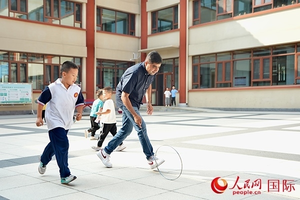 來(lái)自巴基斯坦的沙杰在滾鐵環(huán)。人民網(wǎng) 盧鵬宇攝