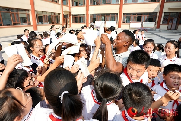 孩子們和選手互動(dòng)簽名。人民網(wǎng) 盧鵬宇攝