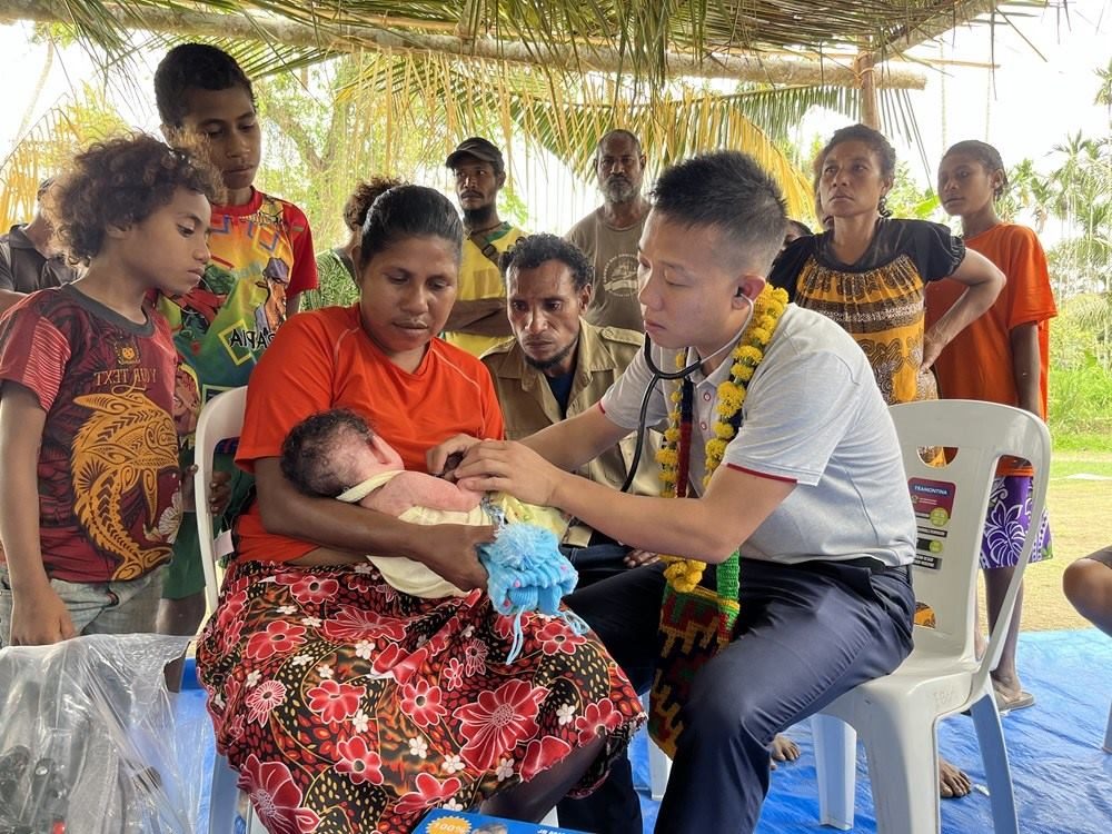2023年8月5日，在巴布亞新幾內(nèi)亞中央省的一個(gè)村莊里，第12批援巴新中國醫(yī)療隊(duì)副隊(duì)長、新生兒科副主任醫(yī)師劉振球?yàn)楫?dāng)?shù)貗雰郝犜\檢查。新華社發(fā)（第12批援巴新中國醫(yī)療隊(duì)供圖）