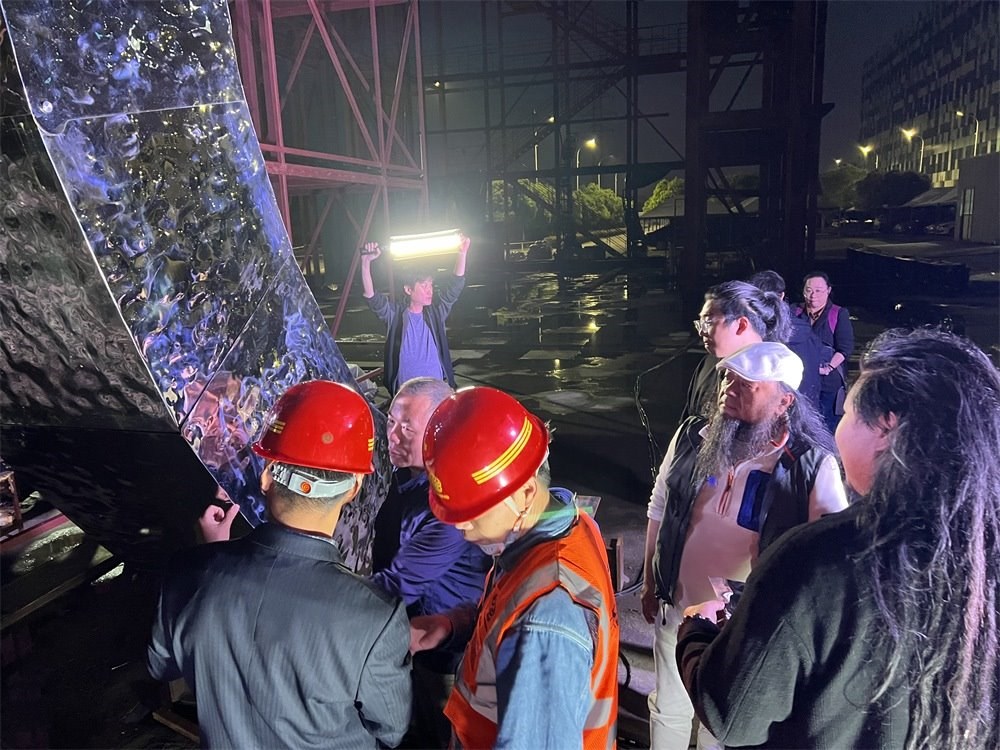 林崗（右二）和團隊查看主火炬制作進度。受訪者供圖