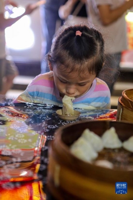 9月27日，小朋友在南翔小籠長街宴上品嘗南翔小籠。